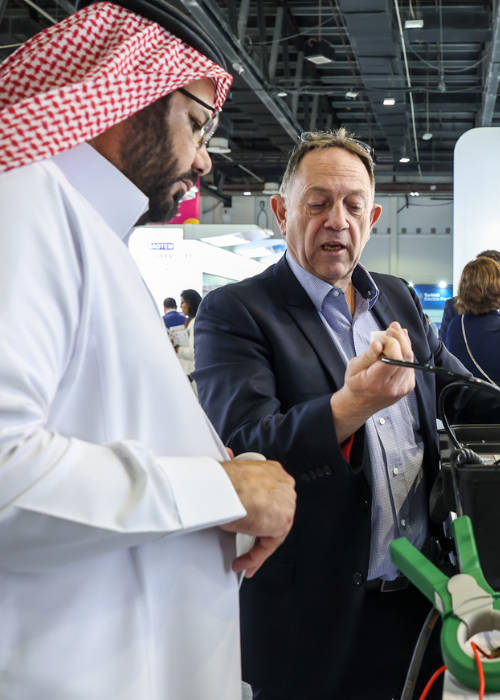 Attendees standing around an exhibition stand